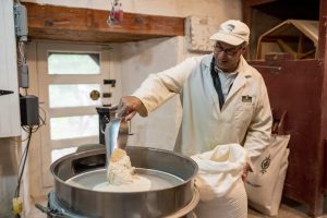 Le maître meunier du moulin Légaré verse de la farine dans un tamiseur.